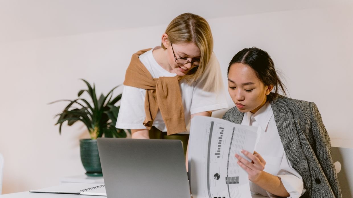 Two colleagues looking at a laptop together.