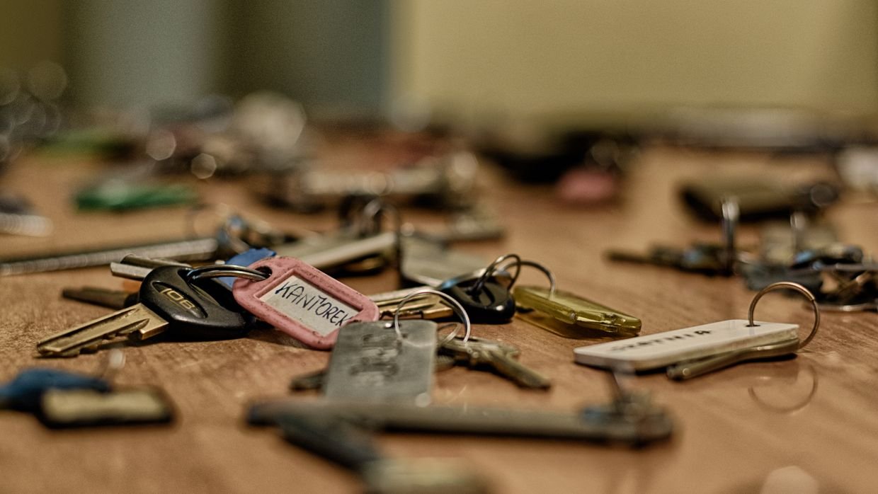 A single key resting on a wooden table.