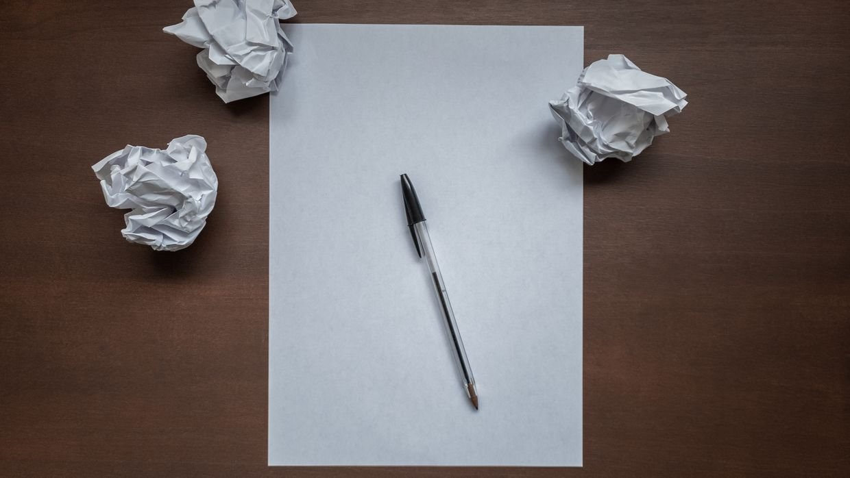 A single sheet of paper on an empty desk.